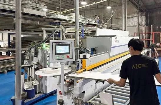 Thợ AIC vận hành máy dán cạnh tại nhà máy